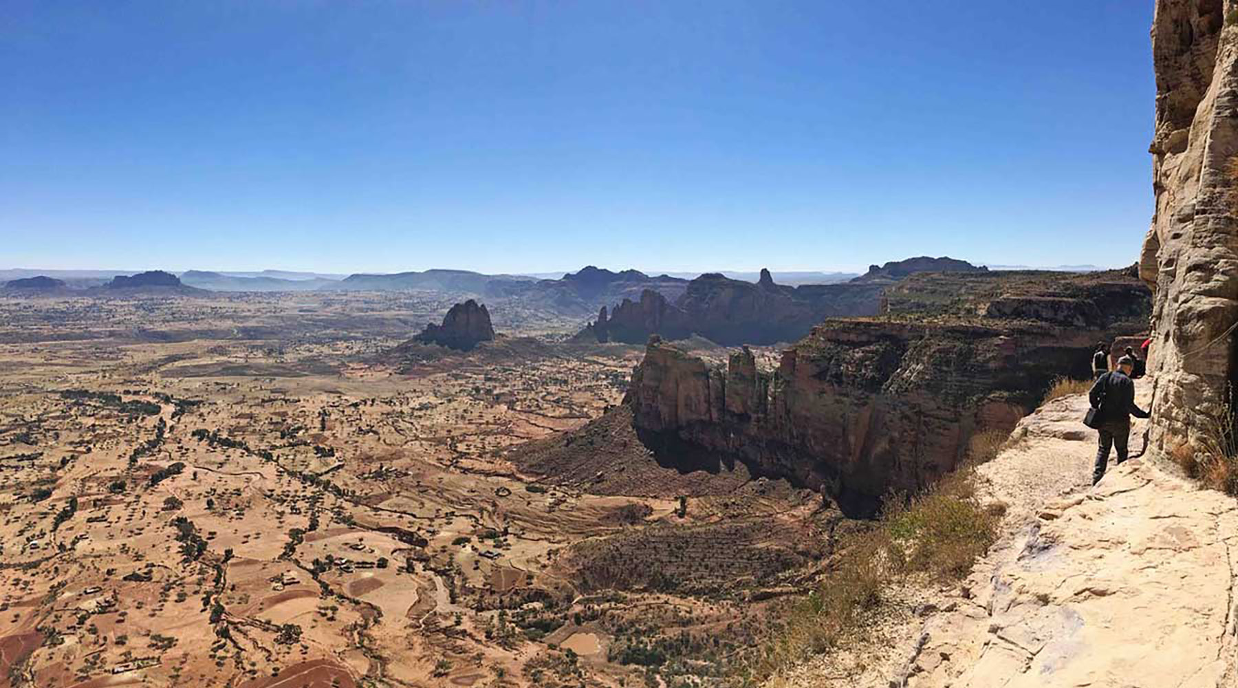 Holidaymakers trek along a the side of a cliff in the Gheralta region of Ethiopia