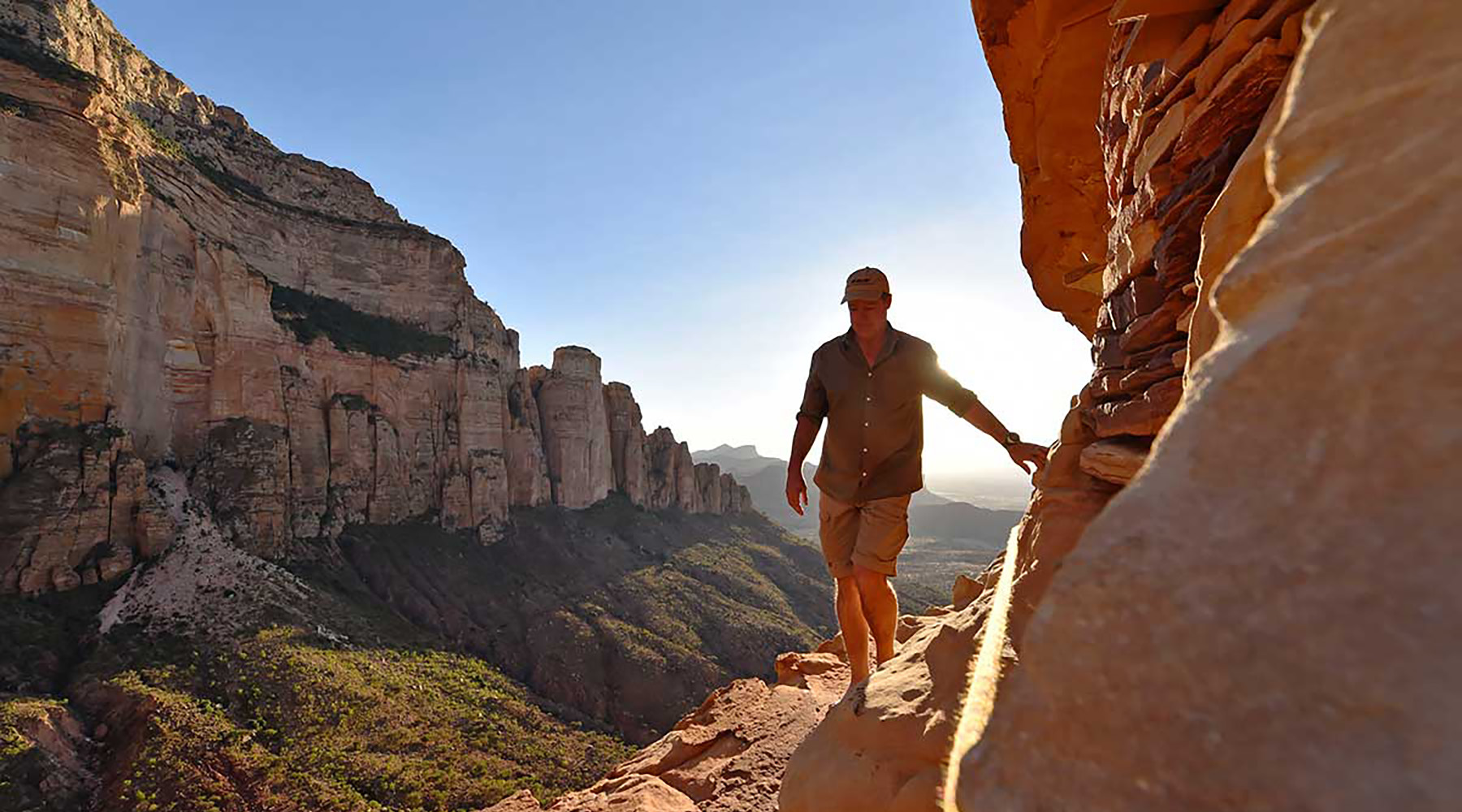 A man walking along a cliff edge in the Gheralta region of Ethiopia